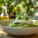 Green spaghetti served in a white bowl with garnishes.